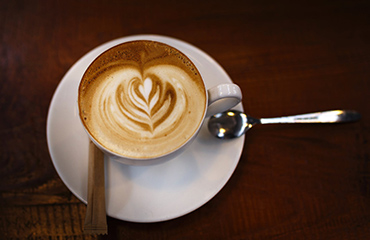 A coffee cup with beans on the side